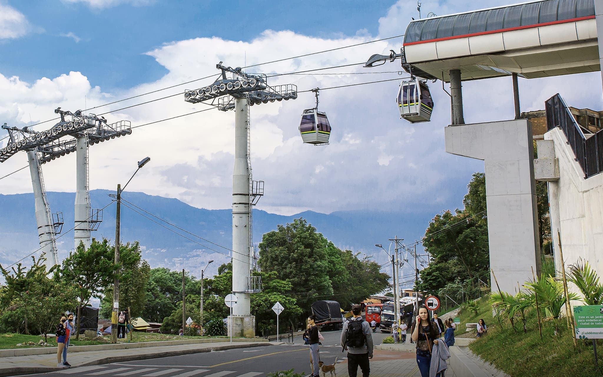 Gondola over urban area with mountains in the background